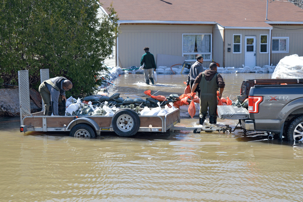 Volunteers help move sandbags to protect a home from rising flood waters near Ottawa Canada, during 2019 floods